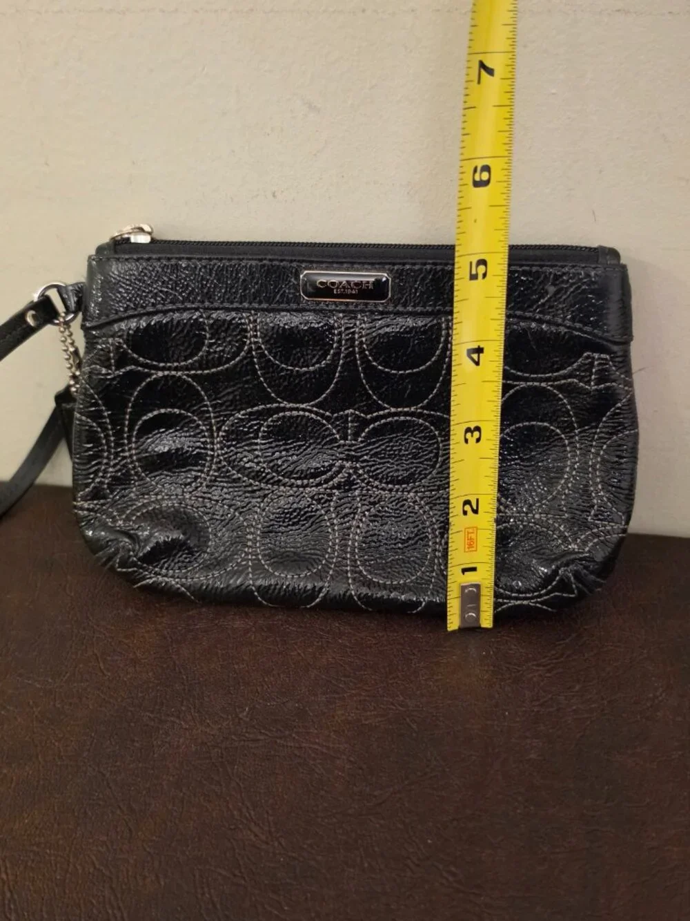 The Coach Signature Stitched Patent Leather Wristlet in black silver